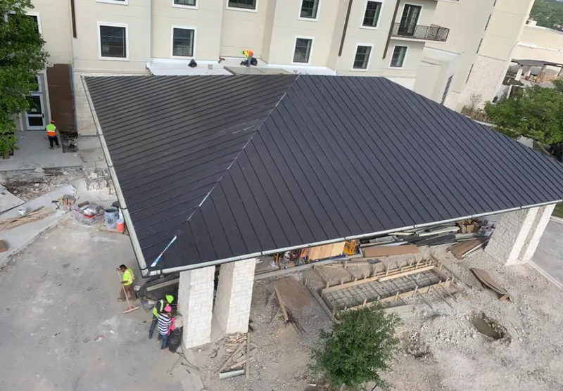 Metal roofing installation team working on a commercial building in Coconut Creek
